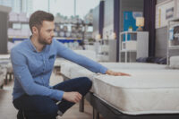 young man testing orthopaedic mattress